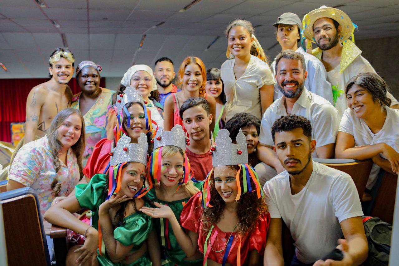 Elenco estudantil da nova montagem de Brefaias reunido, com figurinos e coroas de papel